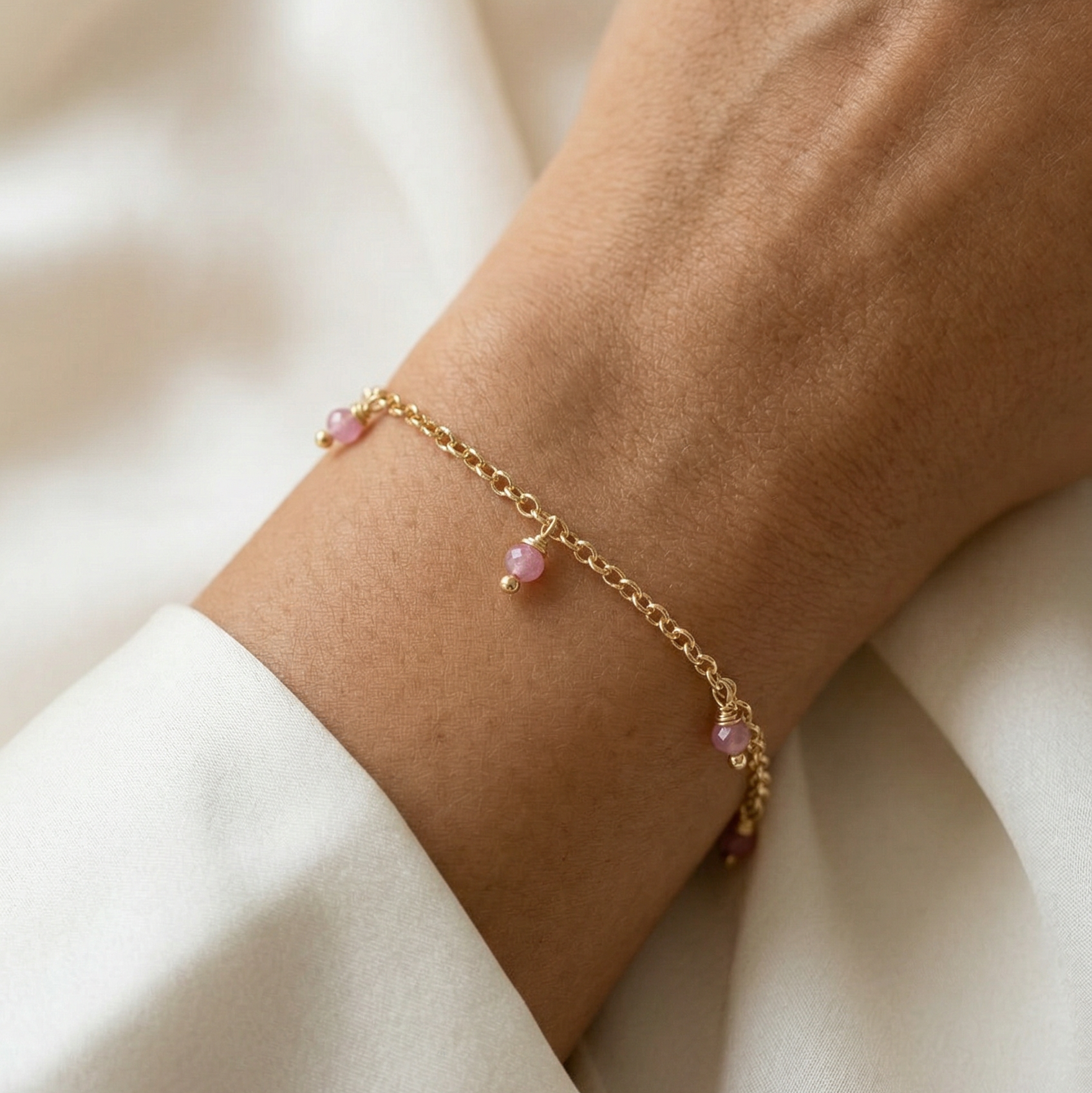 Gouden armbandje met roze steentjes